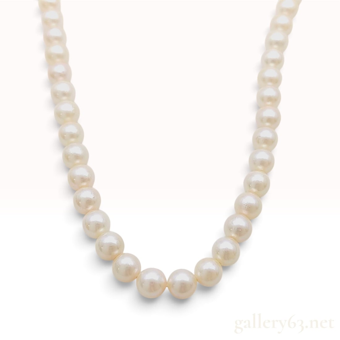 Vintage Silver and Graduated Cultured Pearl Necklace: This graduated cultured pearl necklace is composed of a single strand of cream-toned pearls featuring a high luster and an iridescent orient. The pearls are individually knotted on silk thread and tap