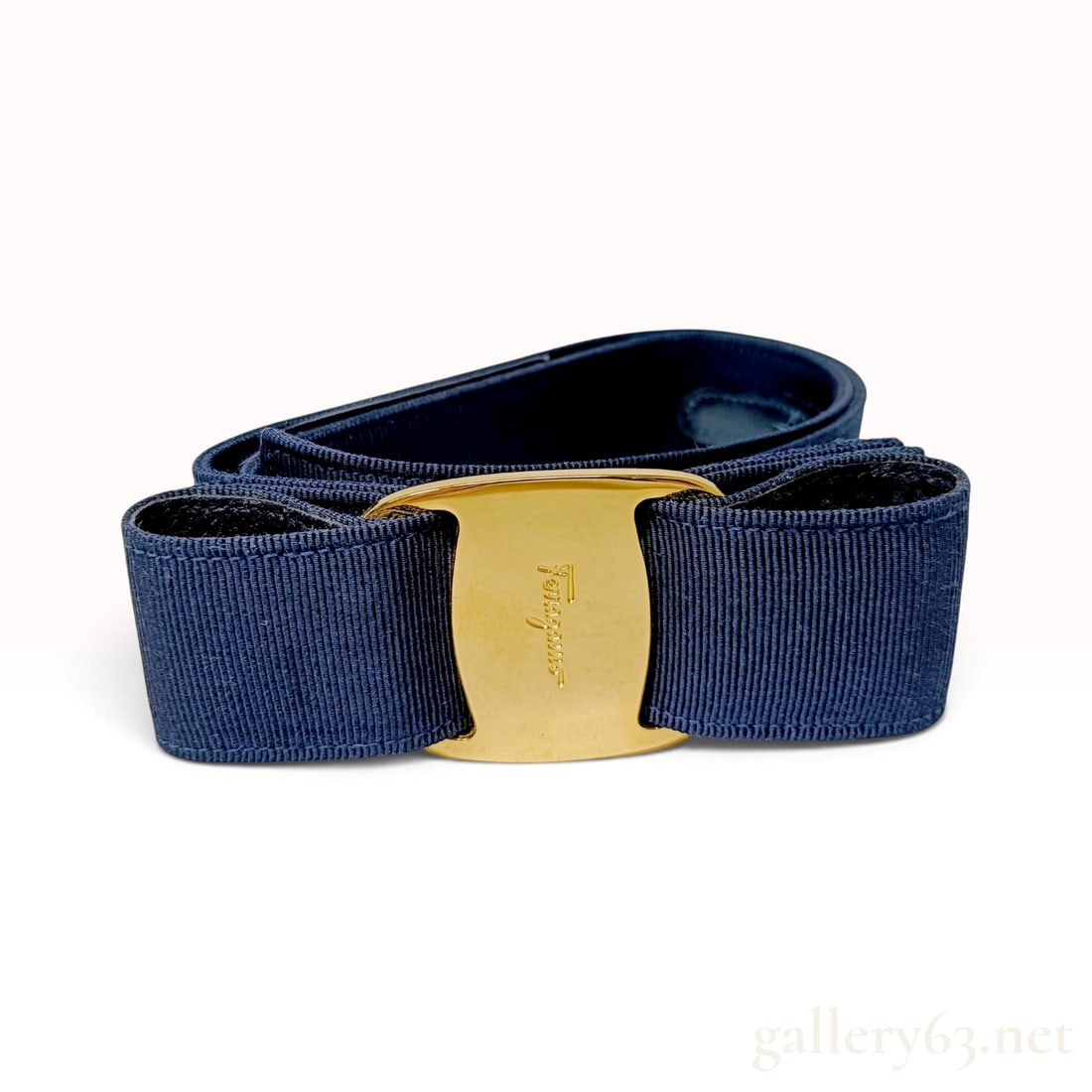 Salvatore Ferragamo Vara Navy Grosgrain Ribbon Belt 75 cm: This Salvatore Ferragamo Vara belt is crafted from navy blue grosgrain ribbon. The design features the signature Vara bow at the front, centered by a polished gold-tone metal plaque. The ribbon is a b