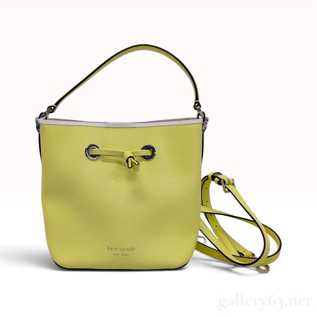 NWT Kate Spade New York Eva Small Neon Yellow Pebbled Leather Bucket Crossbody Bag: This Kate Spade New York Eva Small bucket bag is crafted from vibrant neon yellow pebbled leather. The bag features a classic bucket silhouette with a drawstring closure secured by a knotted leather c
