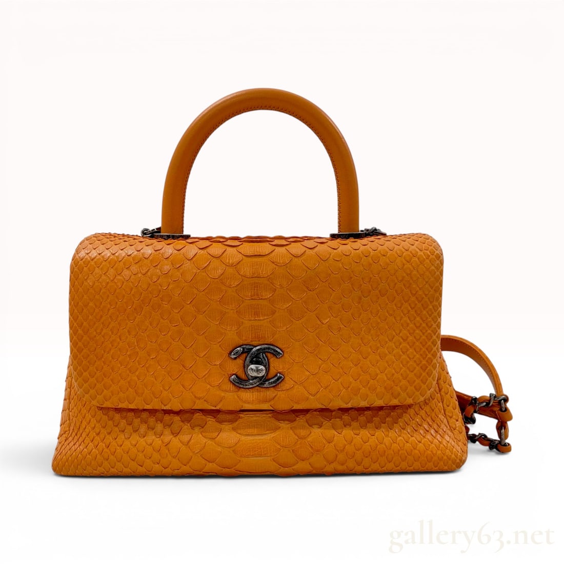 Chanel Orange Python Coco Handle Bag with Aged Ruthenium Hardware: A Chanel Coco Handle bag crafted from vibrant orange python skin with a matching smooth leather top handle and a detachable interwoven chain and leather shoulder strap. The bag features a trapezoidal