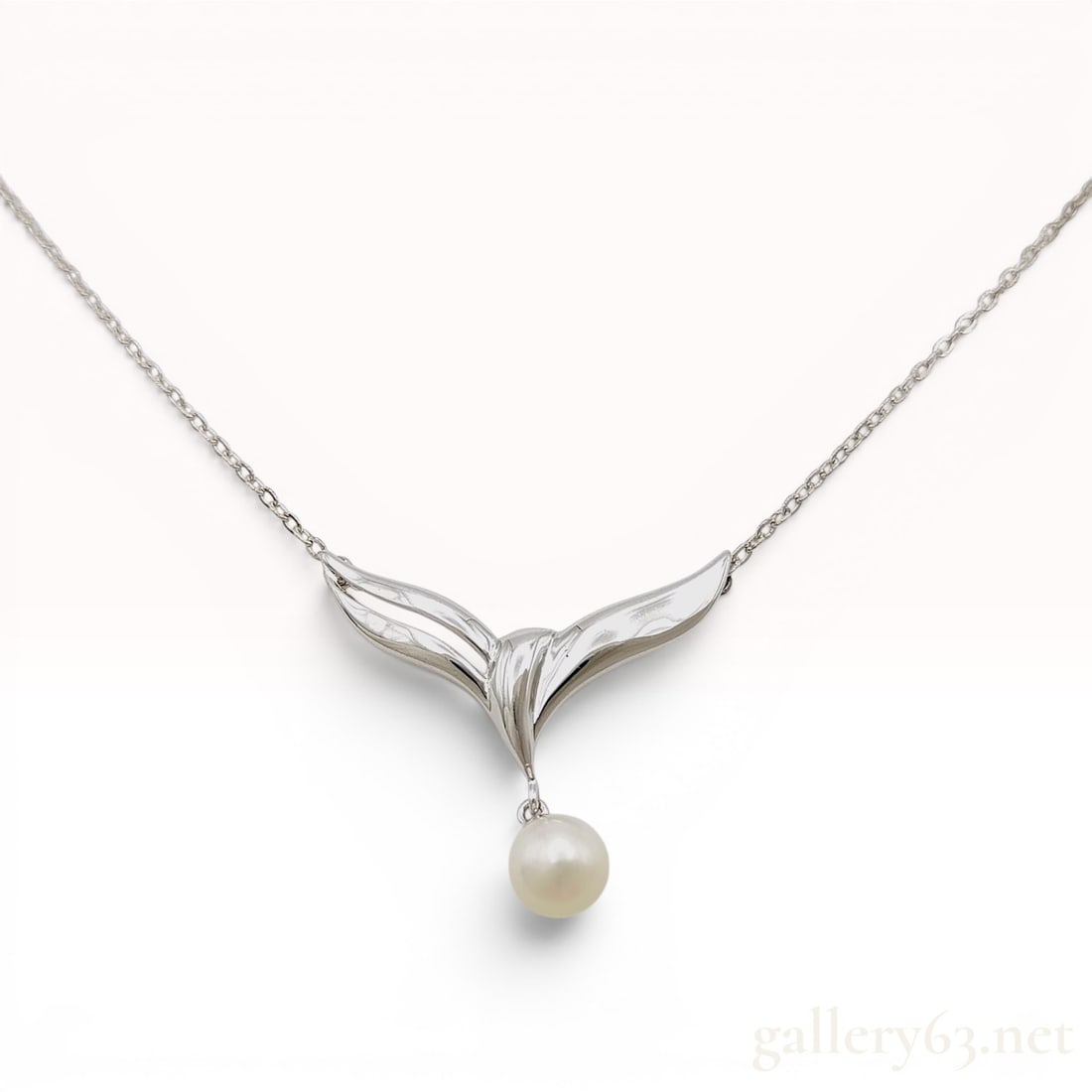Mikimoto Sterling Silver and Akoya Pearl Pendant Necklace: This necklace by Mikimoto features a stylized wing-shaped pendant crafted in silver with a high-polished finish. A single white Akoya pearl is suspended from the center of the chevron-form pendant. Th