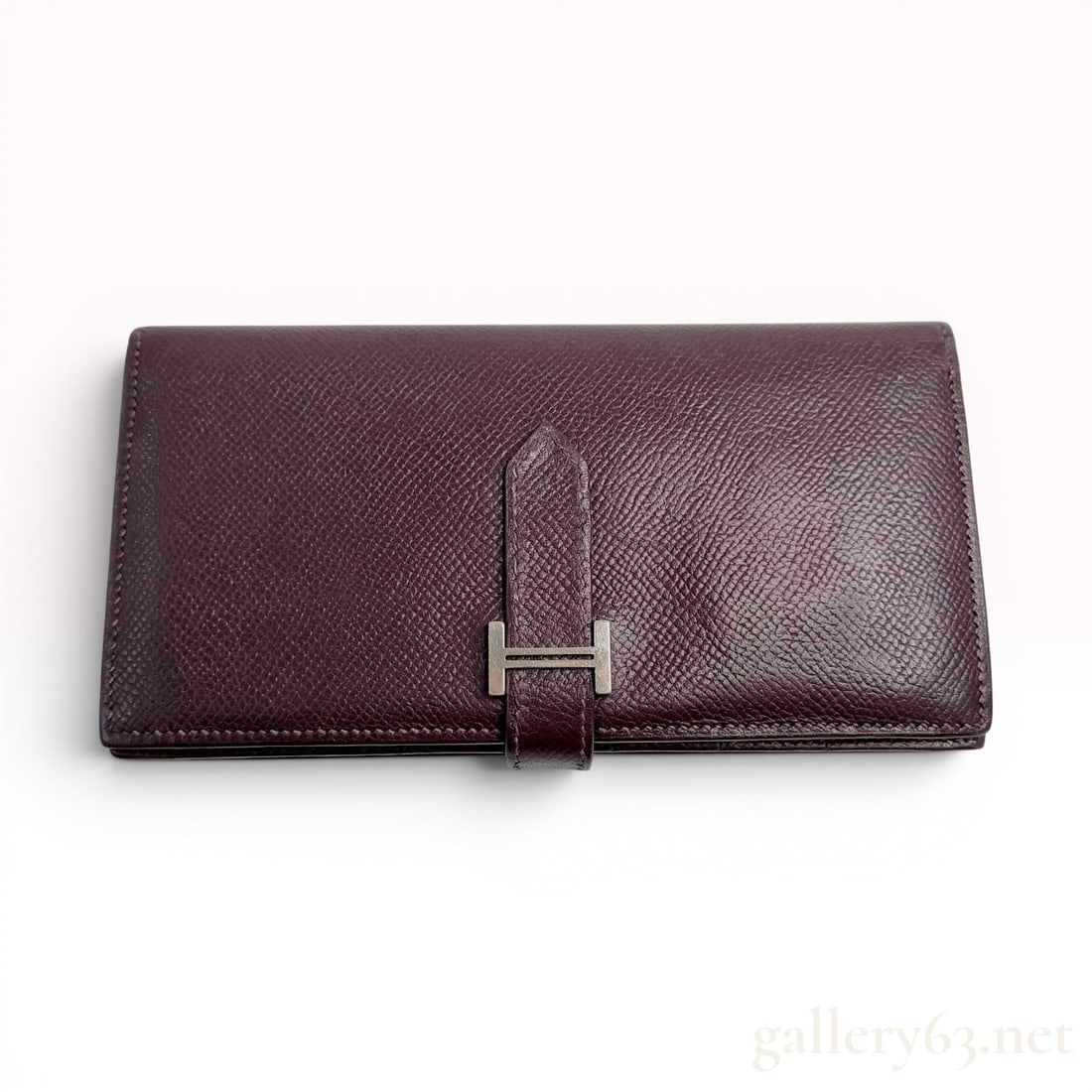 Hermes Bearn Soufflet Long Wallet in Raisin Epsom Leather: Hermes Bearn Soufflet long wallet manufactured in France. The item is constructed from grained Epsom leather in a deep purple Raisin hue. It features a fold-over design with a tab closure secured by a