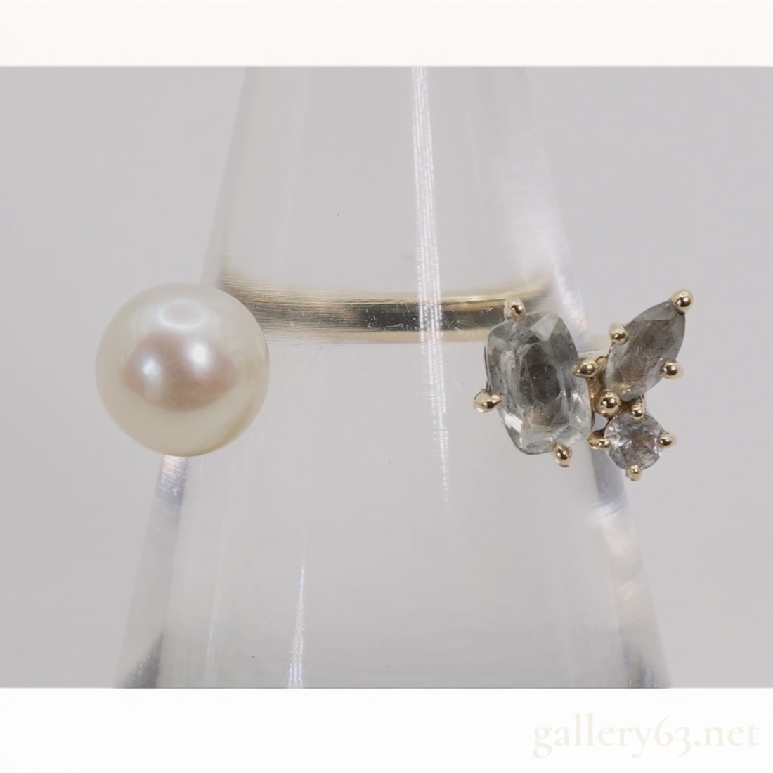 4C 10 Karat Yellow Gold Pearl and Gemstone Bypass Ring: 4C contemporary bypass-style fashion ring crafted in 10 karat yellow gold featuring an open-front design. One terminal is set with a white cultured pearl with pinkish overtones, while the opposite ter