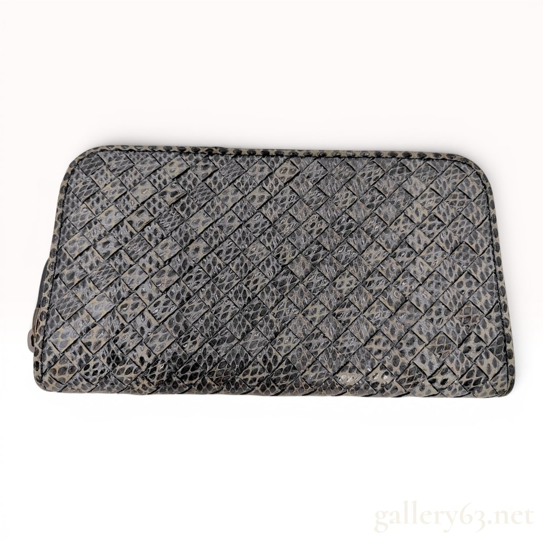 Bottega Veneta Intrecciato Snakeskin Zip-Around Long Wallet: Bottega Veneta zip-around long wallet featuring the house signature intrecciato woven construction in a gray and black patterned snakeskin. The exterior zipper is set on navy blue fabric tape with gun