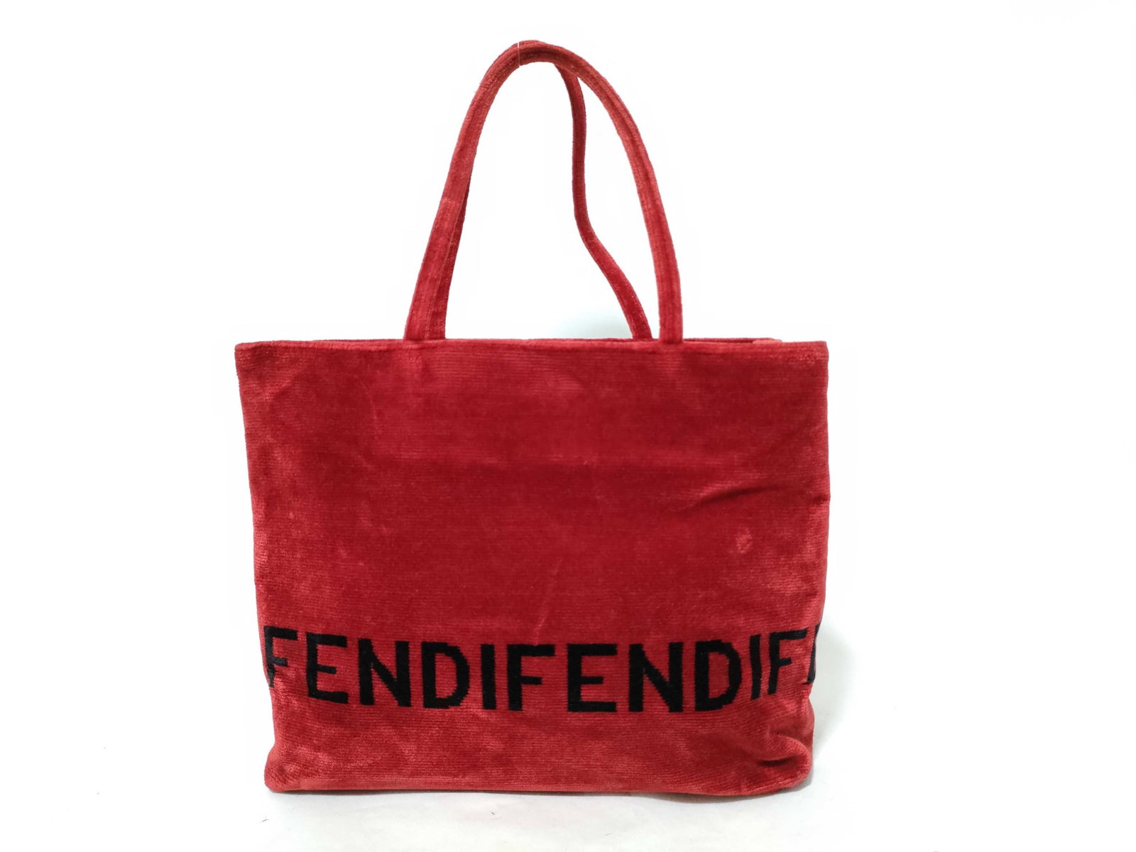 Fendi Red Ribbed Velvet Logo Shopper Tote Bag: A Fendi shopper tote bag crafted from vibrant red ribbed velvet with a plush texture. The exterior features a prominent wrap-around logo in large black block letters reading FENDI. The bag is designed