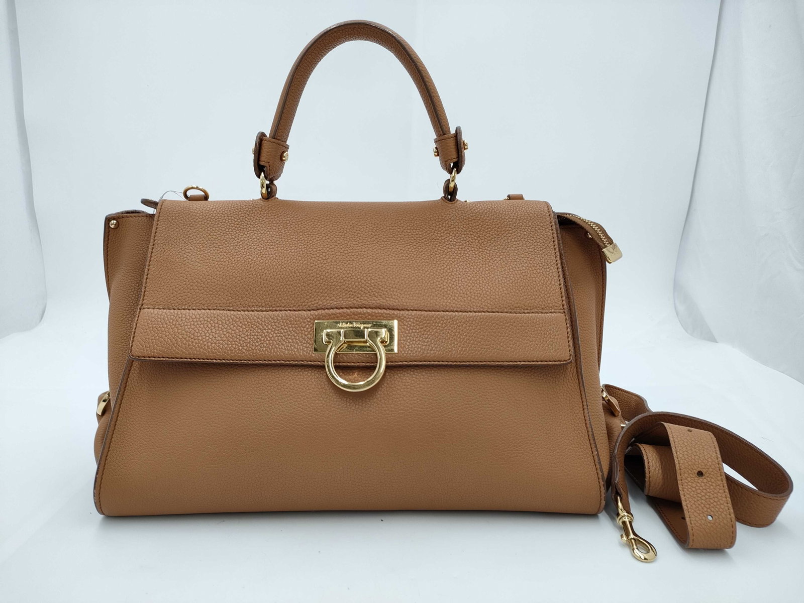 Salvatore Ferragamo Tan Pebbled Leather Gancini 2-Way Handbag with Gold Hardware: Authentic salvatore ferragamo gancini handbag, authentic. made from tan pebbled leather with structured sides and a flat base. features a top handle and an adjustable, detachable shoulder strap for 2-