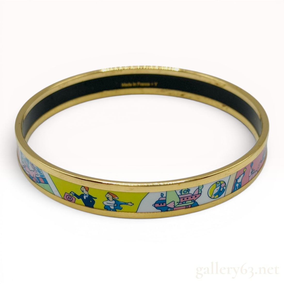 Hermes Tea for Two Narrow Enamel Bangle: An authentic Hermes Tea for Two narrow enamel bangle bracelet. The piece features a gold-tone metal frame with a multicolored enamel inlay depicting figures, animals, and a boat in a cartoon-style ill