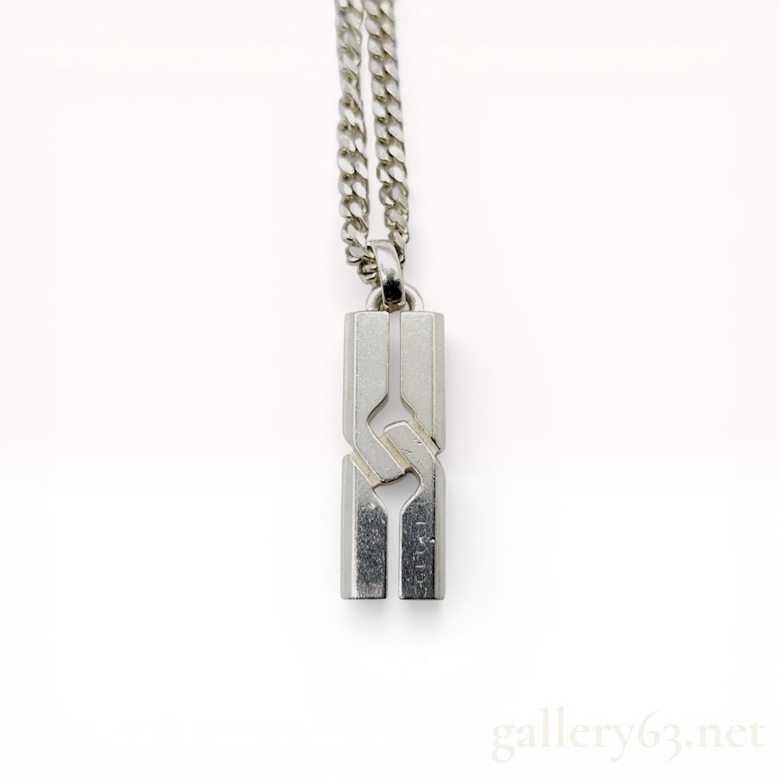 Gucci Sterling Silver Knot Infinity Pendant Necklace: Gucci sterling silver pendant necklace in the Knot Infinity pattern, contemporary. The geometric pendant features interlocking vertical bars with angled cutouts suspended from a matching curb link cha