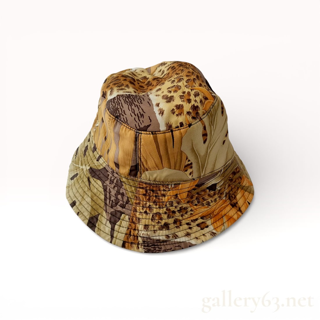 Salvatore Ferragamo Silk Twill Botanical and Leopard Print Bucket Hat: Salvatore Ferragamo bucket hat featuring a botanical and animal motif. The exterior is constructed from silk twill with a print of leopard spots, stylized foliage, and orange flowers, while the interi
