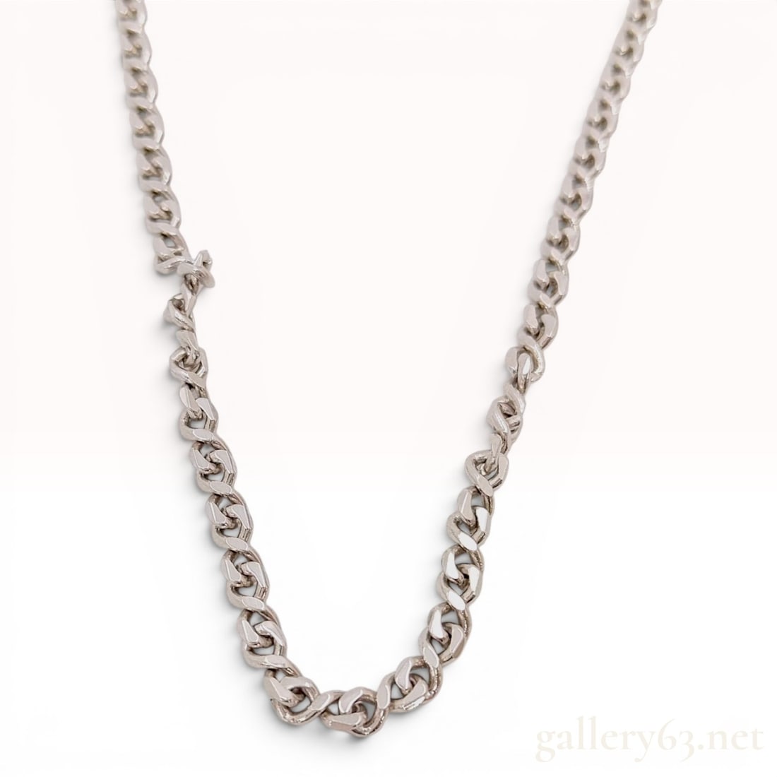 Givenchy Silver Toned Curb Link Chain Necklace: This is an authentic vintage costume jewelry necklace by Givenchy. The piece is constructed from silver-toned base metal and features a variant of a flat curb link chain with a beveled, slightly twist