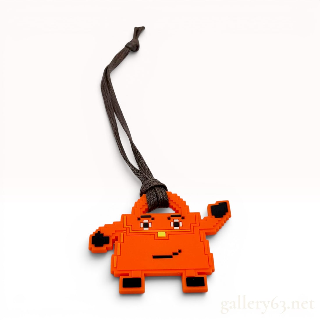 Hermes Quelle Idole Kelly Doll Bag Charm: This molded rubber bag charm features a pixelated design of the Kelly Doll, also known as the Quelle Idole, a signature anthropomorphic handbag design. The charm is constructed from flexible bright or