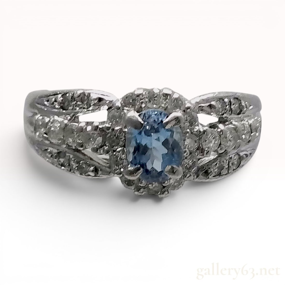 Aquamarine and Diamond Platinum Pinky Ring: A platinum pinky ring featuring a central oval-cut light blue aquamarine and diamond accents. The primary gemstone is a 0.30 carat aquamarine, held in a four-prong setting and surrounded by a halo of 