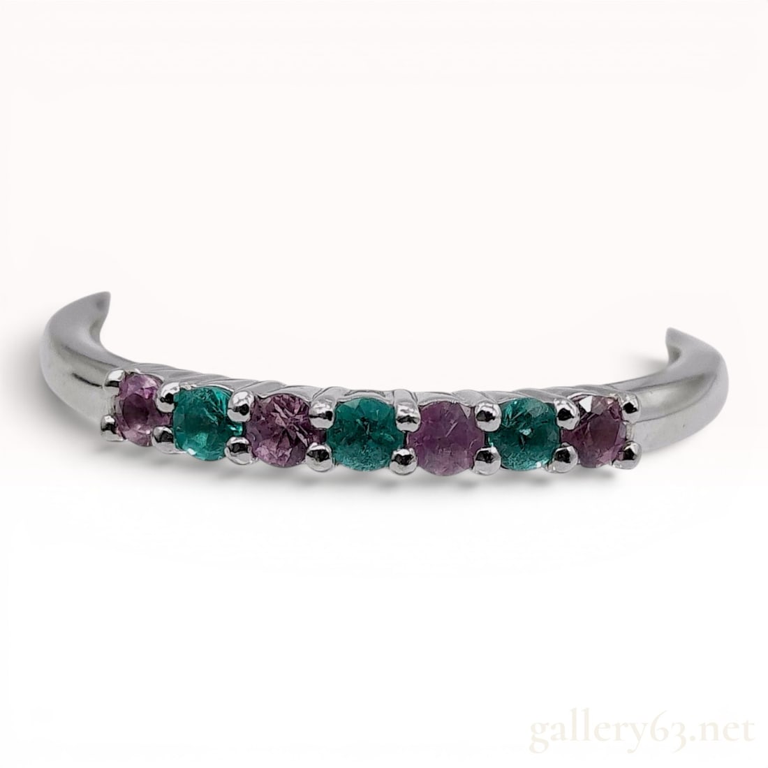 Paraiba Tourmaline and Pink Sapphire Platinum Band Ring: This multi-gemstone band ring is crafted in 900-grade platinum and features seven round-cut stones in a shared prong setting. The stones consist of three neon-green Paraiba tourmalines alternating wit