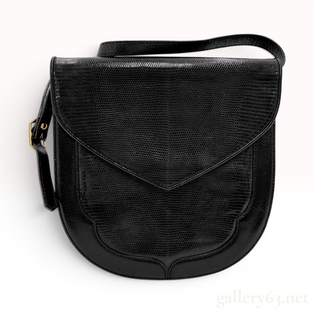 Yves Saint Laurent Vintage Black Genuine Lizard Leather Saddle Bag: This vintage Yves Saint Laurent shoulder bag features a curved saddle silhouette constructed from a combination of smooth black leather and genuine lizard leather panels. The front face and envelope-s