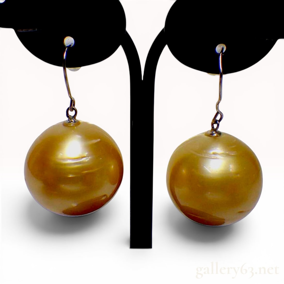 A Pair of Semi-Round Golden Pearl and Pt900 Platinum Earrings: This pair of drop earrings features two semi-round golden pearls suspended from Pt900 platinum hook wires. The pearls possess a rich golden color with a nacreous luster and exhibit natural concentric