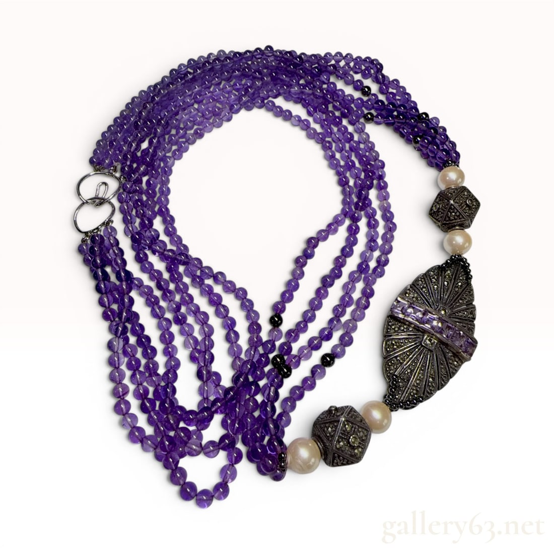 Sterling Silver Multi-Strand Amethyst Marcasite and Faux Pearl Necklace: This Art Deco revival style statement necklace is constructed with four strands of round amethyst beads, each measuring approximately 4mm in diameter. The strands are interspersed with small, dark met
