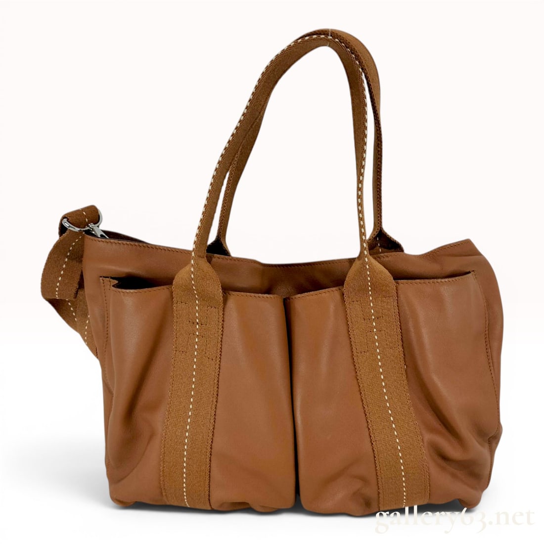 Hermes Caravan Horizontal Brown Leather Tote Bag: Hermes Caravan Horizontal model handbag constructed from supple brown leather with tonal canvas webbing handles and vertical trim. The design is accented with white contrast topstitching and features 