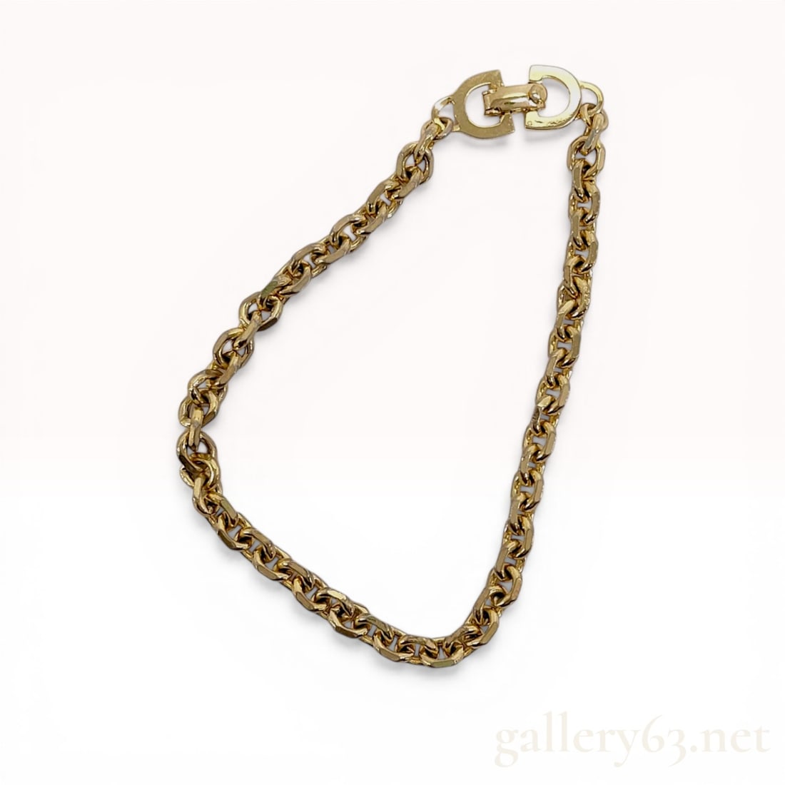 Christian Dior Gold-Tone Faceted Link Bracelet: Christian Dior designer link bracelet, late 20th century. The jewelry features an interlocking chain of faceted oval links in a gold-tone finish. It is secured by a fold-over clasp integrated into a