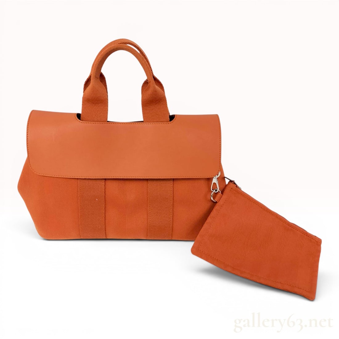 Hermes Valparaiso PM Orange Toile Chevron and Leather Handbag: This Hermes Valparaiso PM handbag is crafted from orange toile chevron canvas featuring a herringbone weave and tonal smooth leather. The bag is designed with dual flat canvas web handles that wrap ar