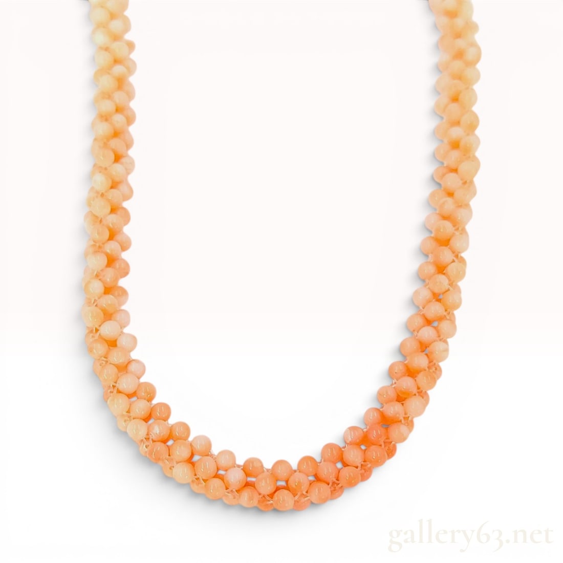 Woven Multi Strand Natural Antique Coral Bead Rope Necklace with Silver Clasp: A vintage multi-strand woven rope necklace composed of natural polished round antique coral beads. The beads, measuring approximately 2mm to 3mm in diameter, display a deliberate color gradient starti