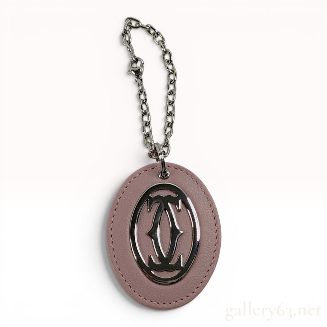 Cartier C Decor Pink Grained Leather and Silver-Tone Bag Charm Key Ring: A Cartier bag charm and key ring featuring an oval-shaped fob in dusty pink grained leather. The fob is constructed with tonal perimeter top-stitching and is inset with a polished silver-tone metal op