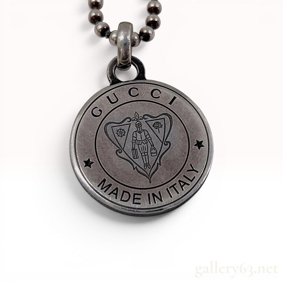 Gucci Sterling Silver Crest Medallion Pendant Necklace with Box: A Gucci sterling silver necklace featuring a circular crest medallion pendant on a ball chain. The pendant displays an embossed Gucci coat of arms on the front, depicting a knight in armor holding a p