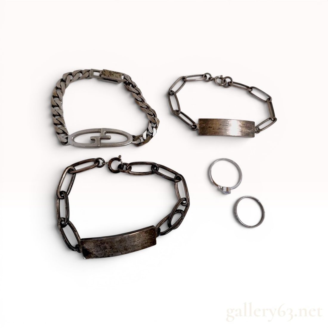 A Collection of Silver Jewelry Including ID Bracelets and Rings: An assortment of sterling silver jewelry from an estate acquisition. Total weight: approximately 60.9 grams Bracelet lengths: approximately 6.75 to 7 inches (17 to 18 cm).