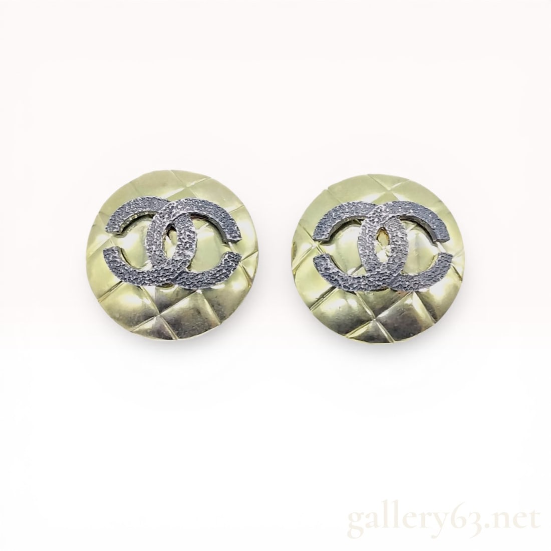 A Pair of Chanel Vintage Quilted CC Logo Clip-On Earrings: Chanel button-style clip-on earrings, late 20th century. Each earring features a domed gold-tone metal base with a quilted pattern and a centered, textured dark-finish interlocking CC logo. The revers