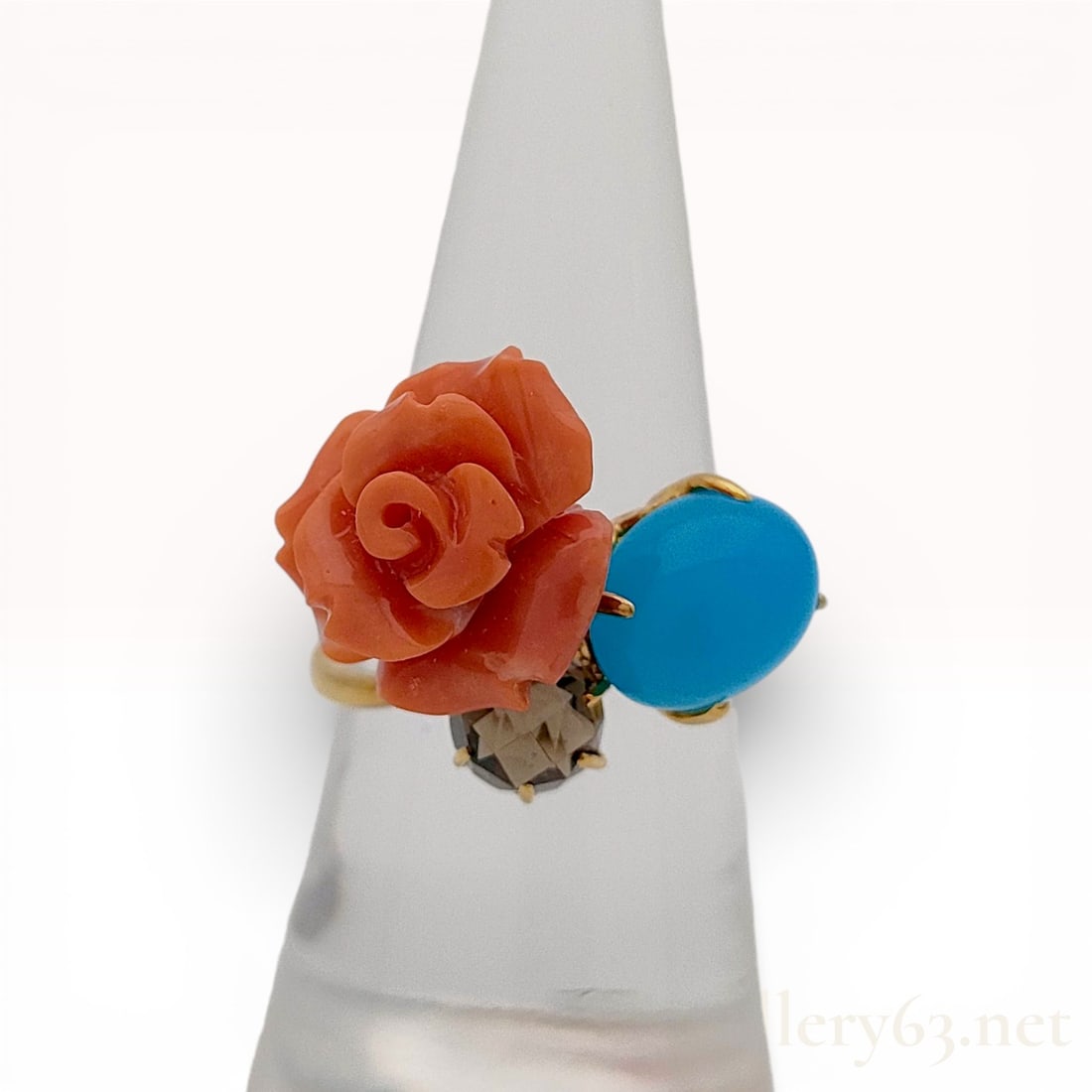 18K Yellow Gold Antique Coral Rose Turquoise and Smoky Quartz Cocktail Ring: An 18K yellow gold multi-stone cocktail ring featuring an asymmetrical cluster design. The setting includes a salmon-colored antique coral specimen carved into a blooming rose, a robin's-egg blue turq