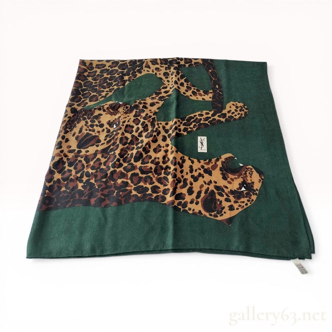 remove put on eli desk i need to measure: Large Yves Saint Laurent square scarf featuring a stylized leopard motif set against a dark forest green ground. The textile is a 70% wool and 30% silk blend manufactured in Japan by licensee Kawabe C