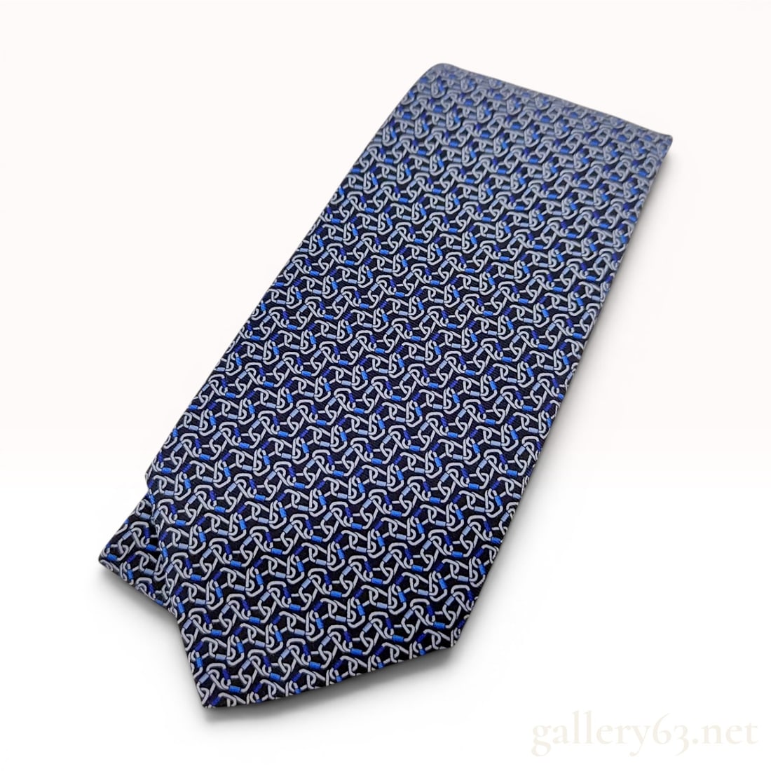 Hermes Paris Silk Necktie Model 645960 TA Climbing Carabiner Motif: Authentic Hermes Paris silk necktie featuring the 645960 TA climbing carabiner motif. The tie is constructed from 100 percent silk and features a dense, repeating geometric pattern of interlocking car