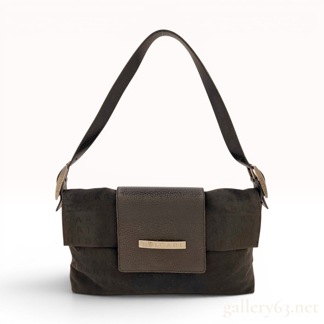 BVLGARI Logomania Black Canvas and Leather Baguette Shoulder Bag: This BVLGARI baguette-style shoulder bag features a black canvas body woven with a repeating tone-on-tone logo pattern. The design incorporates a textured black leather shoulder strap and a matching l
