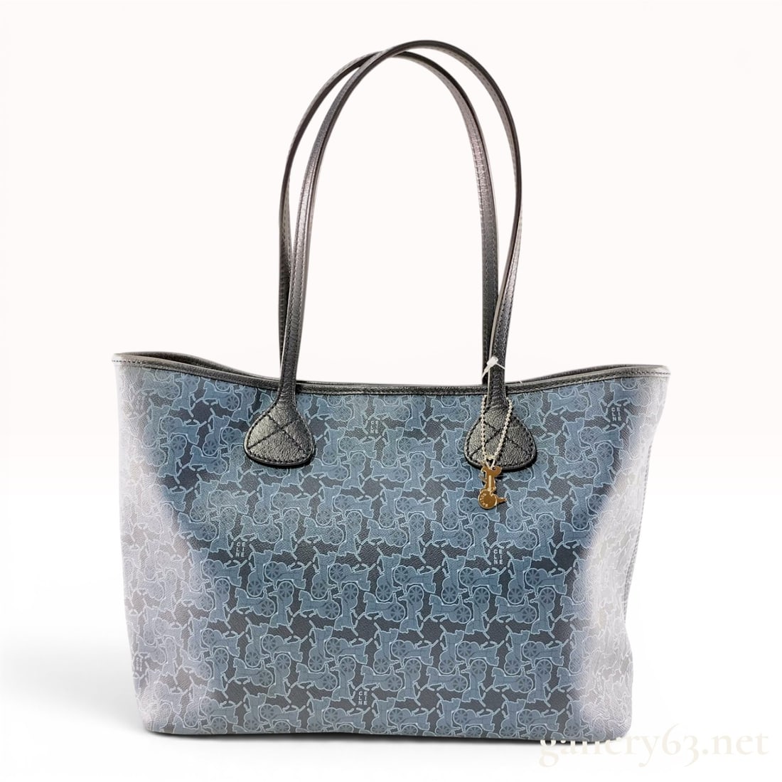 Celine Blue Coated Canvas Horse and Carriage Monogram Tote Bag: This Celine open-top tote bag is constructed from blue and grey textured coated canvas featuring the house signature horse and carriage monogram pattern interspersed with the Celine name. The exterior