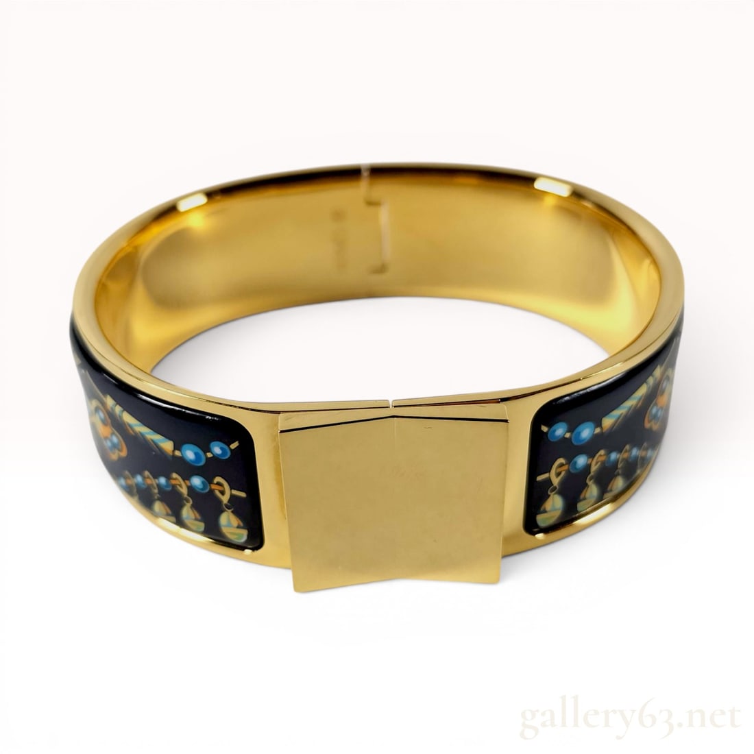 Hermes Wide Printed Enamel Loquet Bracelet PM: A wide enamel hinged bangle bracelet by Hermes featuring gold-plated metal hardware. The exterior is set with enamel panels decorated in the Les Cles (The Keys) pattern, which depicts stylized keys, b