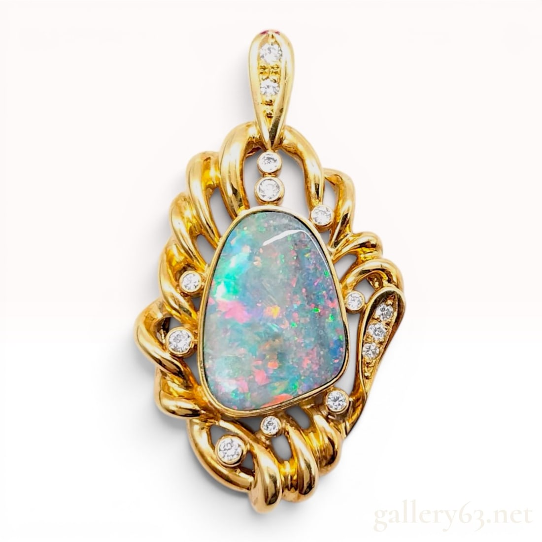 18K Yellow Gold Boulder Opal and Diamond Pendant: This 18 karat yellow gold pendant features a central 5.02 carat freeform-shaped boulder opal. The opal is bezel-set and displays a multi-color play-of-color with flashes of green, red, orange, and