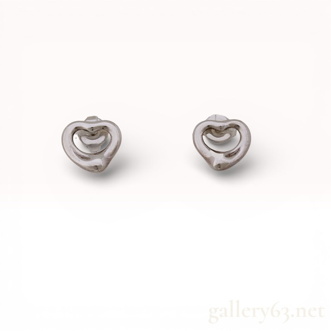 A Pair of Tiffany and Co. Elsa Peretti Sterling Silver Open Heart Stud Earrings: Tiffany and Co. Elsa Peretti Open Heart stud earrings in sterling silver. This matched pair features the signature open heart motif with butterfly friction back closures. The reverse of each heart is