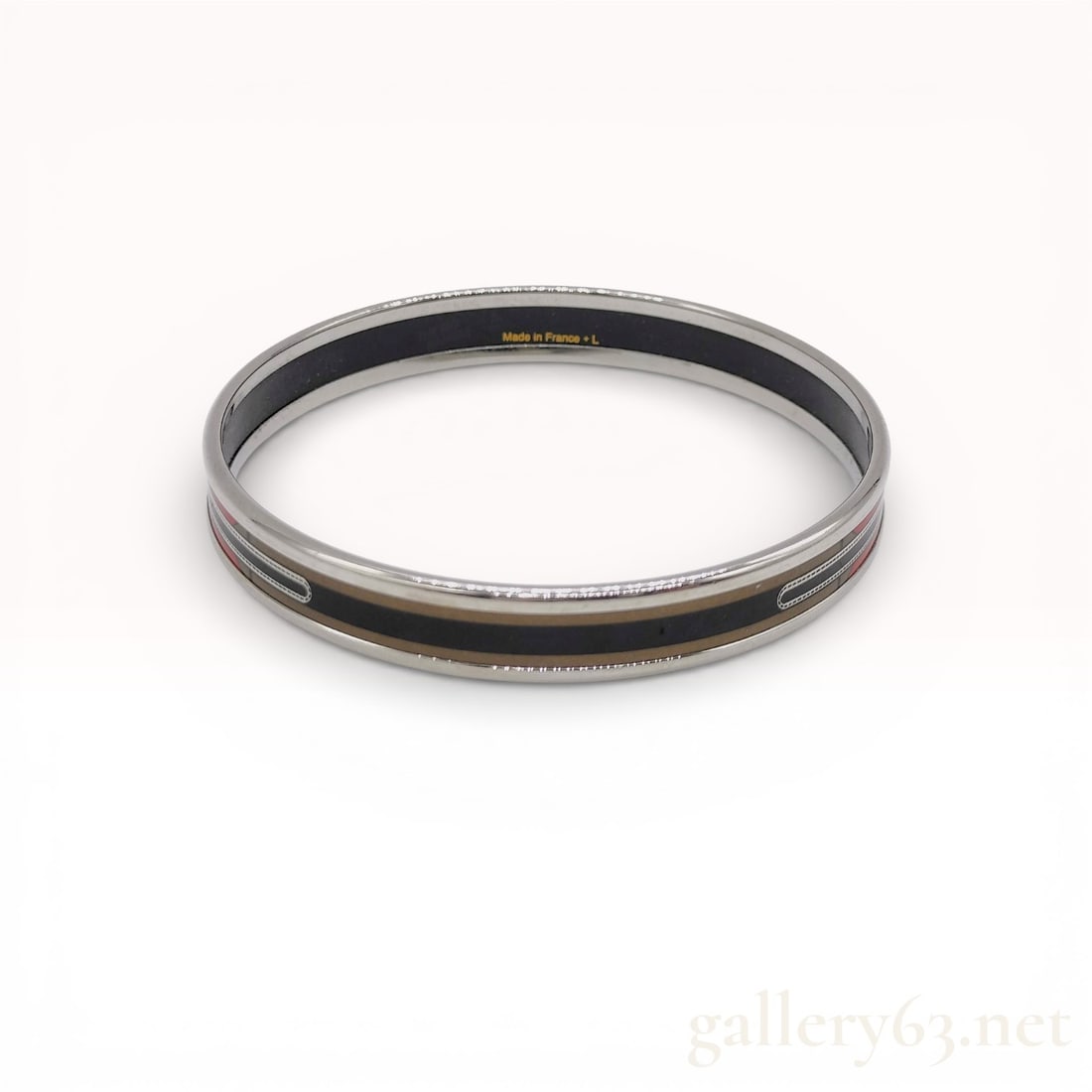 Hermes Narrow Enamel Bangle with Belt and Buckle Motif: Hermes narrow enamel bangle bracelet in a belt and buckle motif, late 20th century. Palladium-plated metal construction with a printed enamel inlay in red, black, and gold tones. Interior is marked Ma