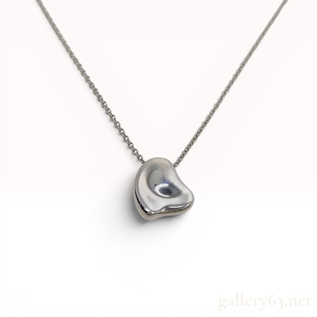 Tiffany & Co. Elsa Peretti Sterling Silver Full Heart Pendant Necklace: A sterling silver pendant necklace from the Elsa Peretti collection for Tiffany & Co. The necklace features a solid, asymmetrical Full Heart pendant with an organic, three-dimensional form and a high-