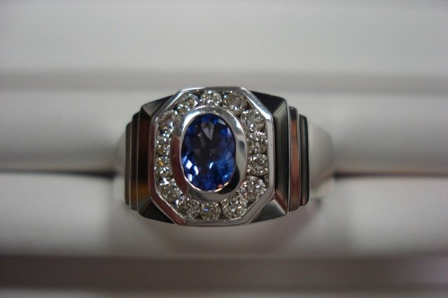 Men's18k white gold, tanzanite and diamond ring: Gents 18 carat white gold, high polished tanzanite and diamond ring. 14 round brilliant cut diamonds, channel set, surrounding oval cut bezel set genuine tanzanite of gem quality. Diamonds F/G color, 