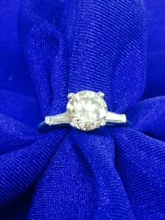 1.55 Carat VVS clarity diamond solitaire: Lady's 18k Diamond Ring. Center Brilliant cut Diamond 1.55 carat, vvs clarity, K-L color. There are two taper baguette diamonds one on each side, total weight .35 carat.