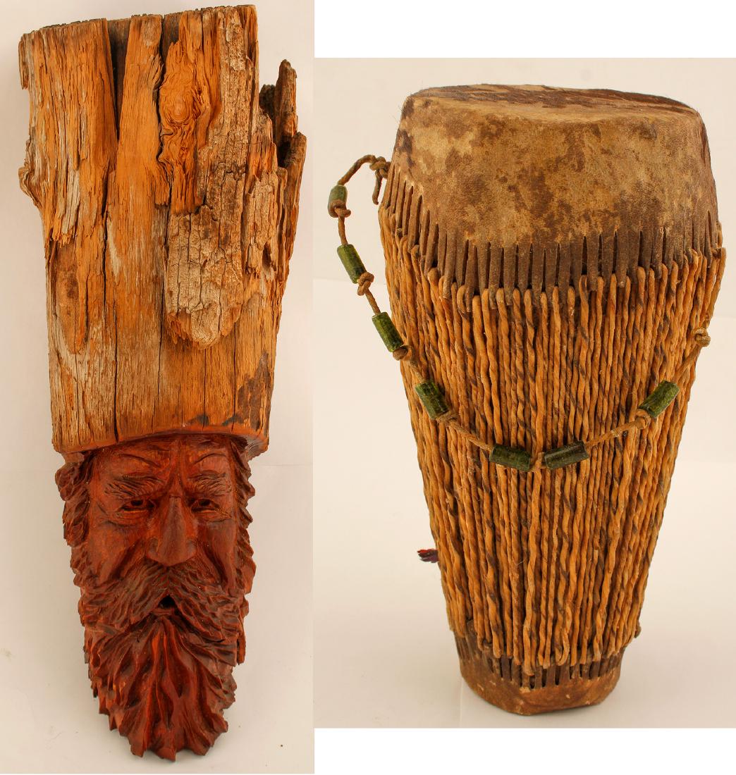 Folk Art Pieces (77859): Two folk art pieces. small drum held between knees, 10" tall, 5" around at the top, stretched leather cover, origin unknown. hand carved hardwood bearded man on small log. artist name not legible now,