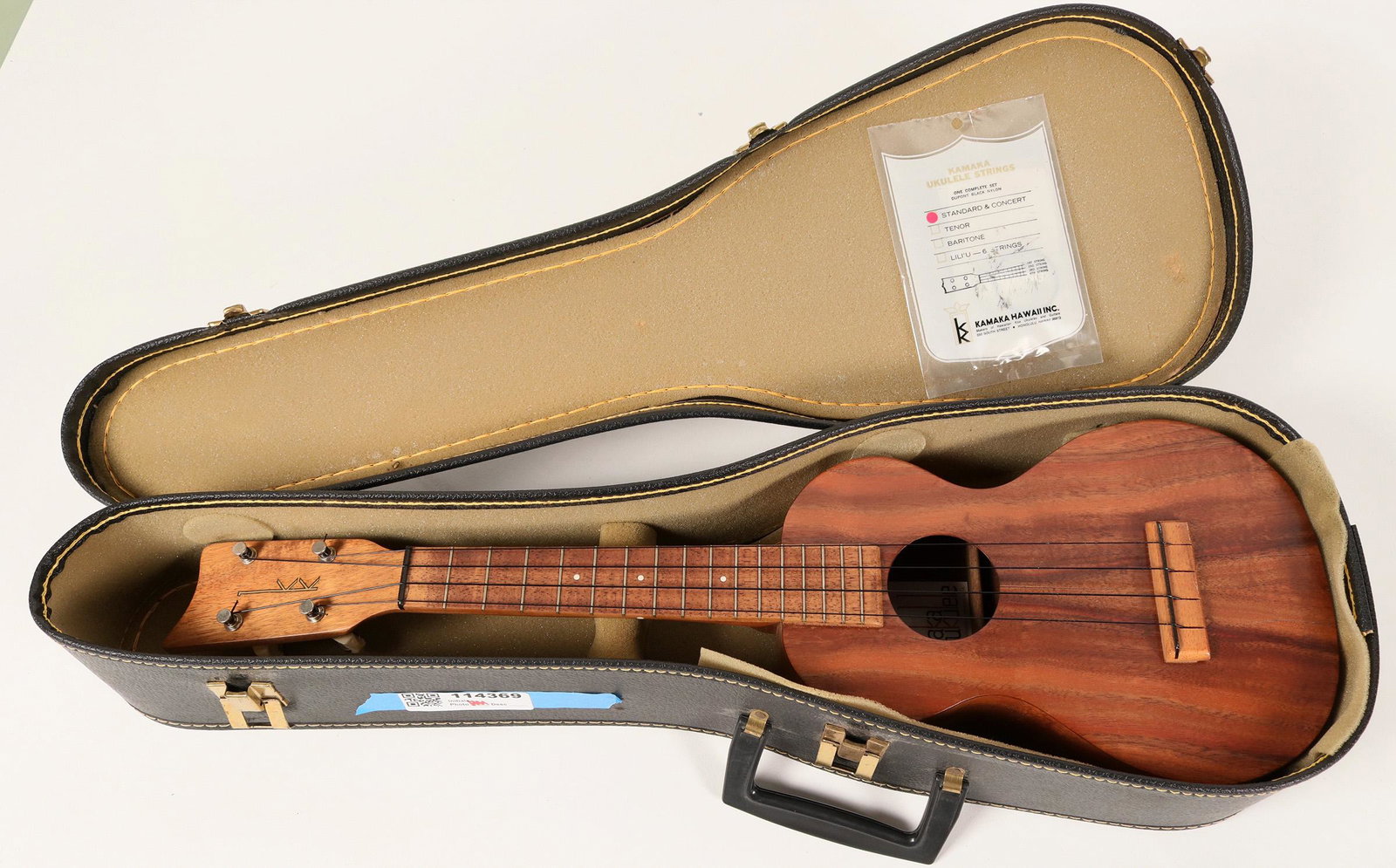 Kamaka Concert Ukulele White Label (114369): Lot of 1. Handmade Kamaka Standard/Concert Ukulele. Made by Kamaka Hawaii Inc. About 24 inches overall length. Includes a white interior label with a white background and red and black lettering. Come