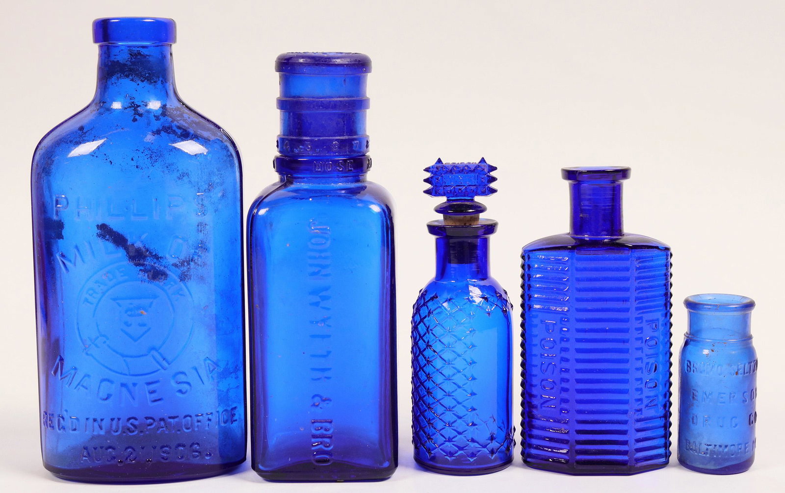 Cobalt Blue Antique Bottle Group (114272): Five bottles: hexagonal poinson 4.5"; round spoison with poison top, 4.5"; Wyeth & Bro eye wash with top measure cup 6.5"; Phillips Milk of Magnesia 7"; Bromo 2.5" Provenance: Country (if not USA): St