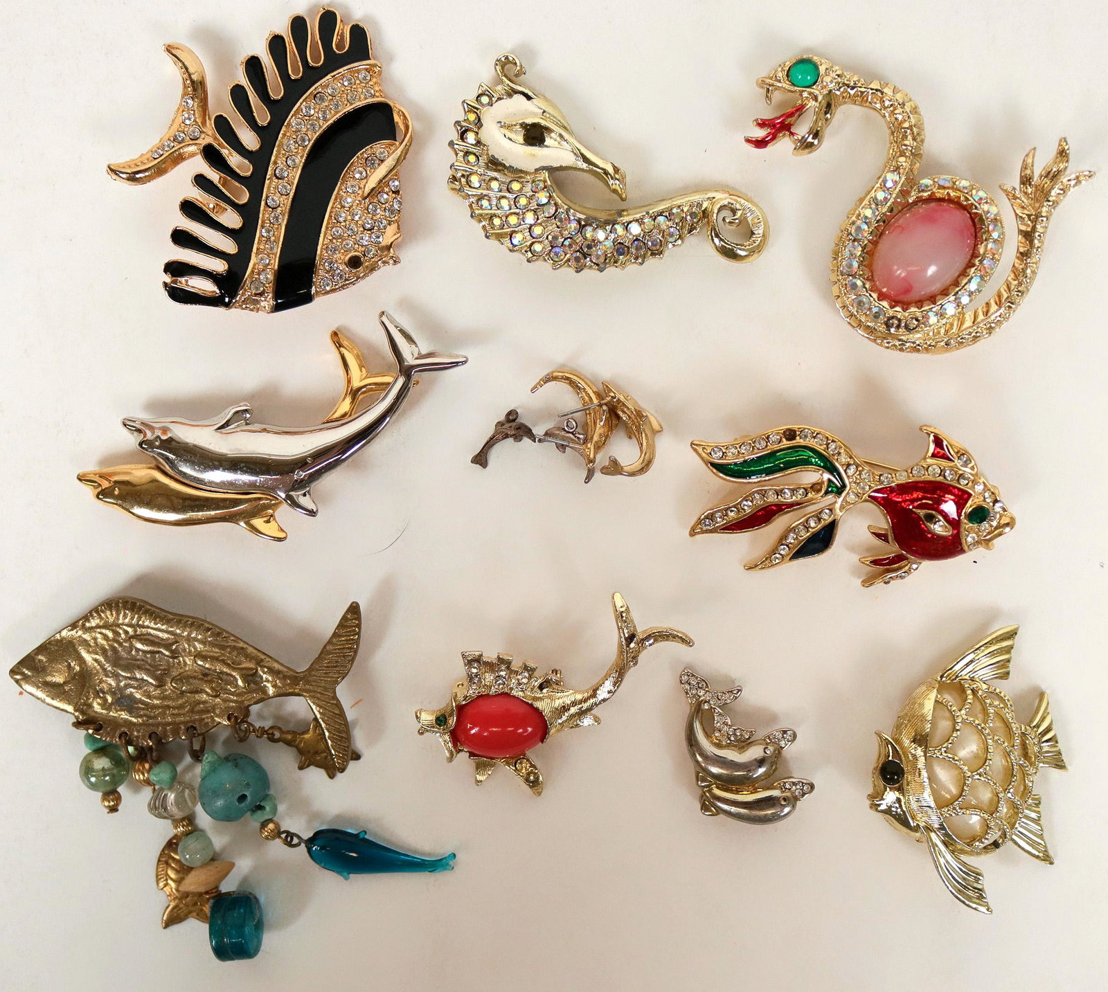 Lapel pins (114759): Fisherman? Love the sea and its inhabitants? Here are 11 beautifully embellished lapel pins to reflect your passion as well a pair of dolphin pierced earrings with one pair of charms. To mention a few