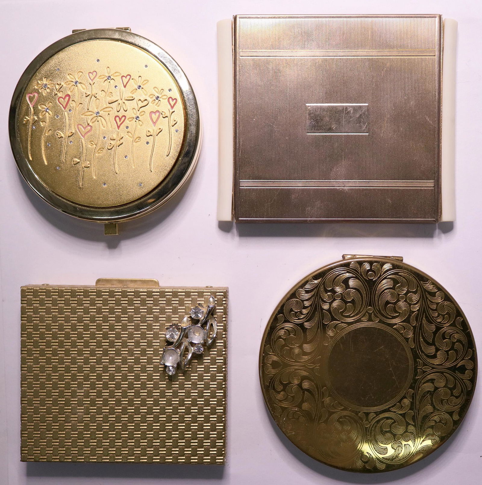 Vintage Ladies' Designer Cosmetic Compacts (Lot of 4): 1) Cosmetic Compact dual mirror with elegant floral design of hearts in red and rhinestones like new condition 2) Harriet Hubbard Ayer New York gold tone square powder vanity compact with mirror has f