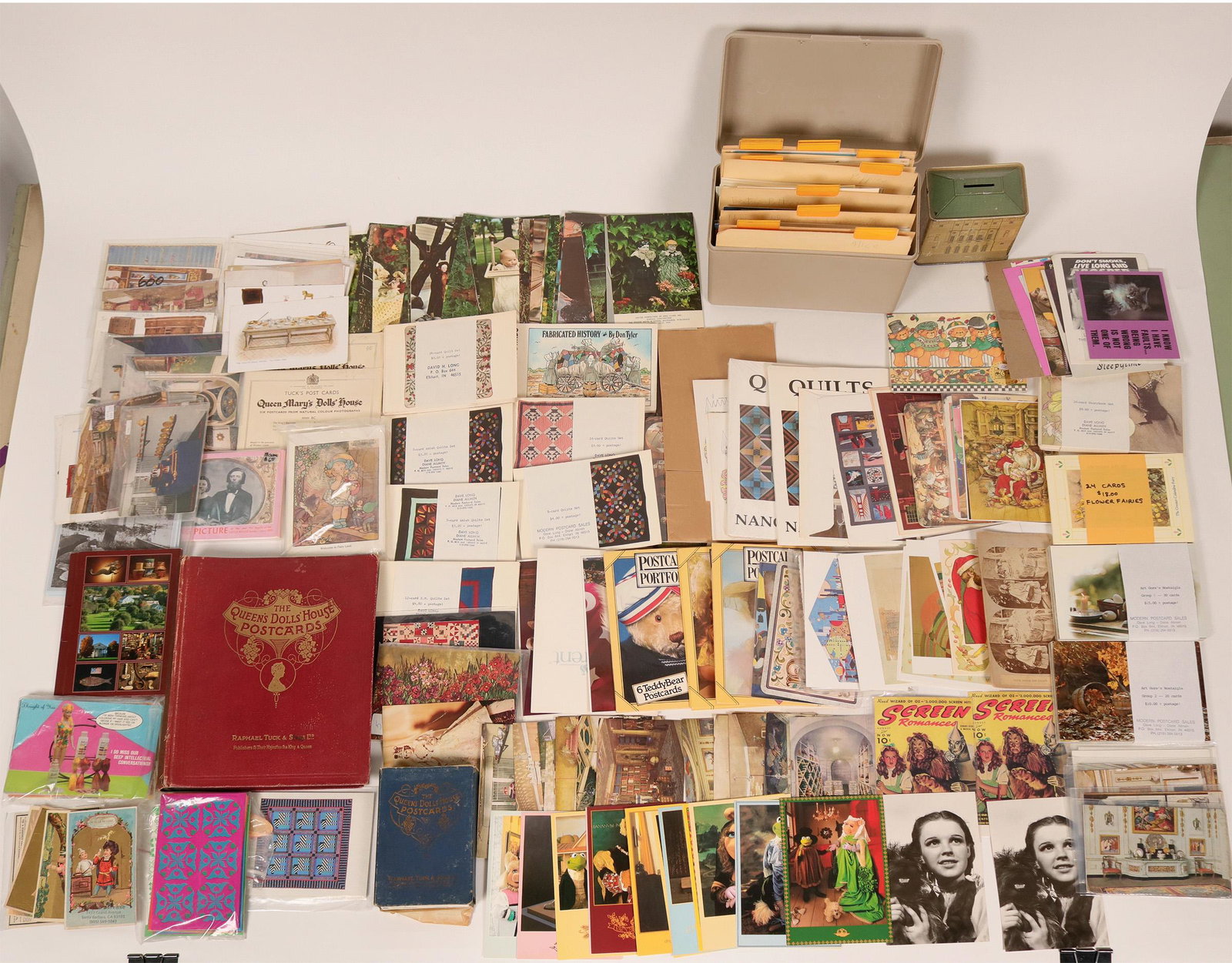the Queen's Doll's House book of Postcards and a Coin: This book published by Raphael Tuck & Sons is a collection of Her Majesty the Queen's doll house as a benefit funds raiser. The book is generally in very good condition and all postcards are intact. T