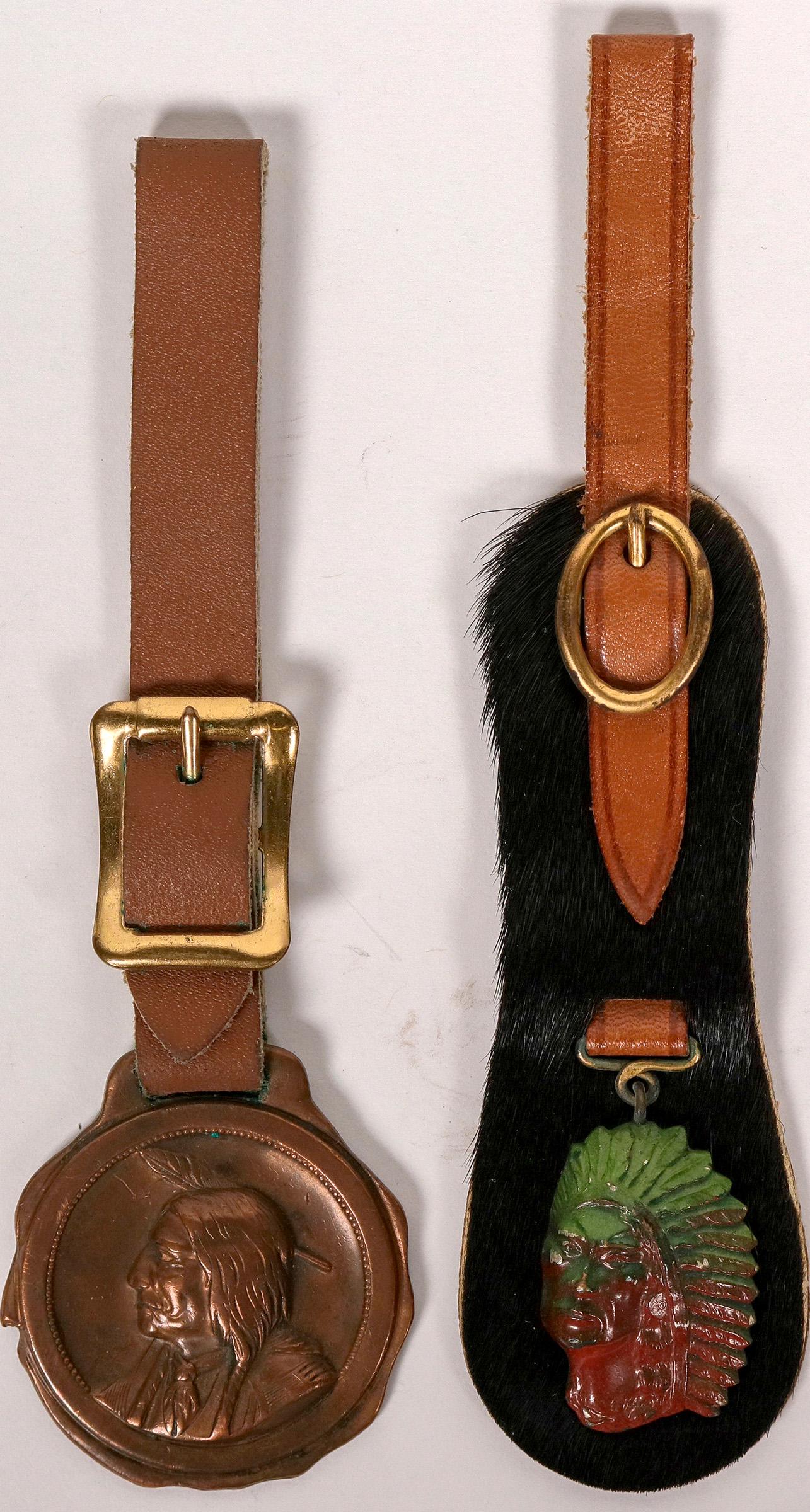 Native American FOB / Medal - Lot of Two (118182): 1) Native American chief. Painted green and red. Concave metallic design. Leather with hair on front holds strap and FOB together. Nice look! Strap included. Height of metal is 1 1/4 inches. 2) Medal
