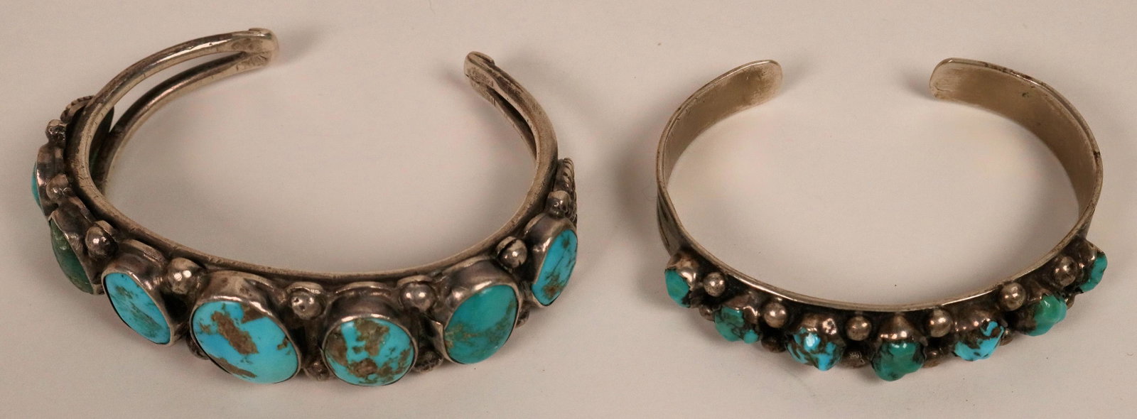 Vintage Navajo Turquoise Cuffs (121099): One large cuff set with 6 natural rough cut turquoise stone and 1 green stone. Heavy sterling--5.5inside measurement, 1.25" opening. the other is a smaller version , same design, set with 7 rough cut 
