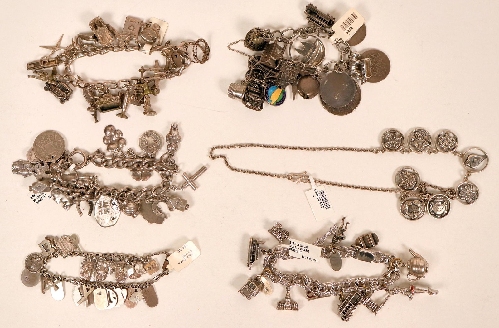 Charm Bracelet and Necklace (121520): A group of five silver charm bracelets and a charm necklace. Charms include everything from Disney World to a San Francisco cable car, thimbles, teapots and more. Total weight of the group is a hefty 