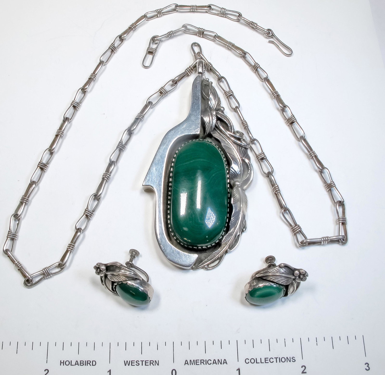 Malachite Necklace Set (125172): This is a beautiful malachite necklace set with silver work in a floral pattern to the right side of the pendant and also positioned above the screw back earrings ,the large malachite pendant measures
